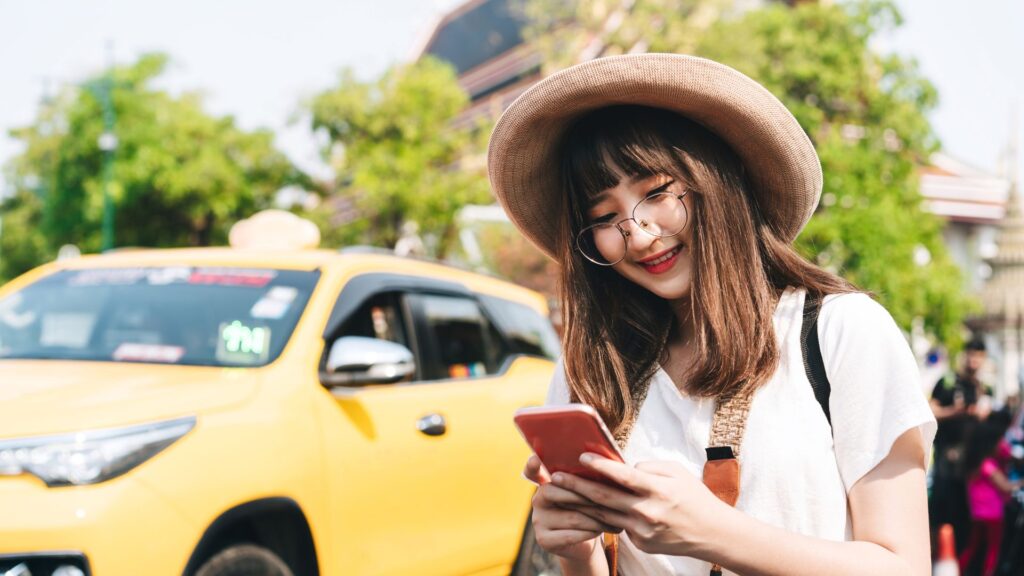 Traveler using her phone on the street to navigate with the best travel planning apps