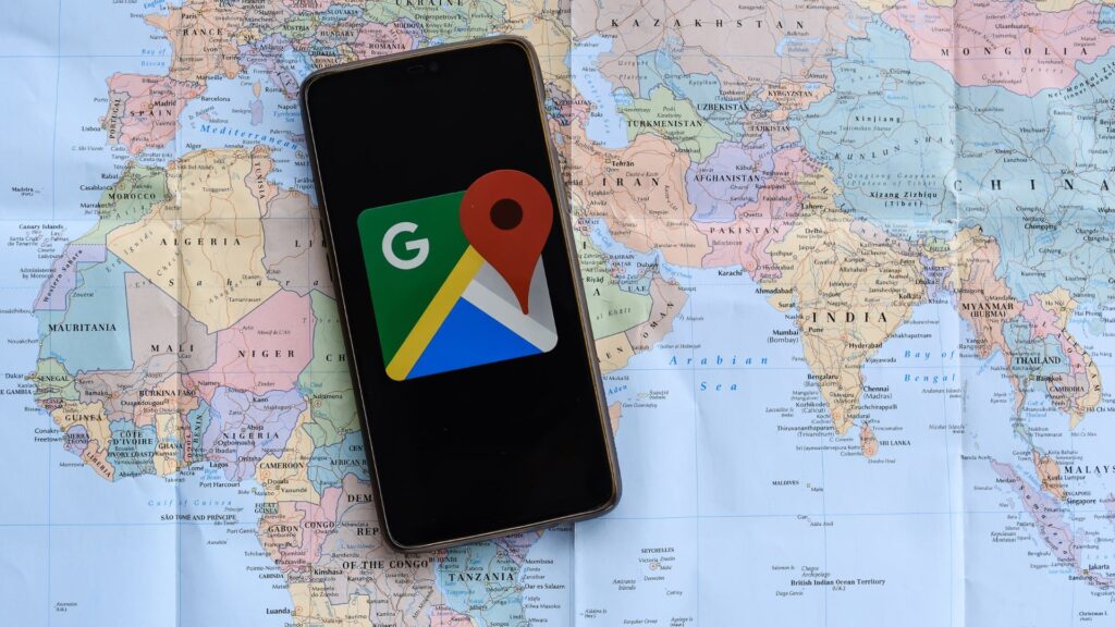 World map with a smartphone showing a map app, highlighting the best travel planning apps for travelers